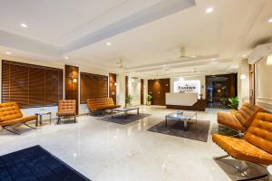 a lobby with couches and a podium in a building at Hotel Exotica Avenue - Business-Friendly Stay, Golf Course Road, Cyberhub, One Horizon Center & Metro in Gurgaon