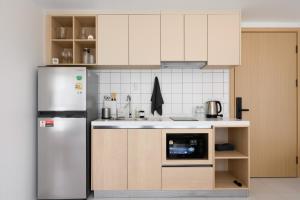 a kitchen with a stainless steel refrigerator and cabinets at Kamala - 5 Min to Beach - Family Stay with 2 Baths in Kamala Beach