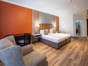 ein Hotelzimmer mit einem Bett und einer Couch in der Unterkunft ANEW Hotel Highveld Emalahleni in Witbank