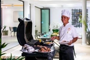 a chef is holding a plate of food at Villa Turquoise in Bophut  +83 photos