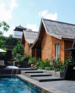a house with a swimming pool next to a house at Twinseas Villa in Uluwatu