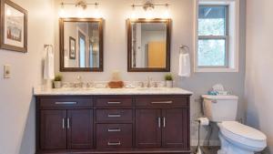 a bathroom with a sink and a toilet and mirrors at River Meadows by AvantStay Near River w Hot Tub Access to Private Boat Ramp in Bend +36 photos