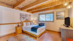 a bedroom with a bed and a television in it at Jeffrey Pines Lofted Cabin Minutes to Lake A-Frame-Inspired Design Deck in Truckee