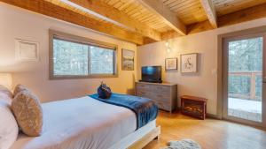 a bedroom with a bed and a tv in it at Jeffrey Pines Lofted Cabin Minutes to Lake A-Frame-Inspired Design Deck in Truckee