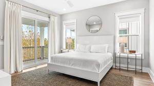 a white bedroom with a bed and a mirror at Sea Dweller by AvantStay Rooftop Spa Gulf View Golf Cart Pool in Inlet Beach +60 photos