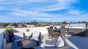 a patio with a table and chairs on a roof at Sunset Serenity by AvantStay Rooftop w Hot Tub Fire Pit 3 Blocks to Beach in Pismo Beach