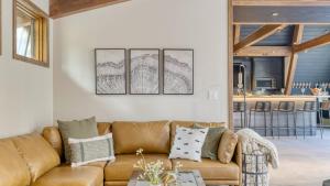 un soggiorno con divano marrone e tavolo di Lazy River Glamp-House by AvantStay Newly Built Luxe Indoor-Outdoor Living a La Pine