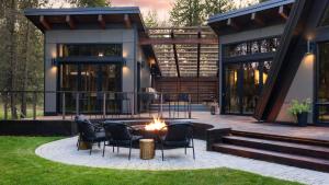 a patio with chairs and a fire pit in front of a house at Lazy River Glamp-House by AvantStay Newly Built Luxe Indoor-Outdoor Living in La Pine