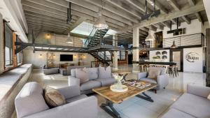a large living room with couches and a table at Skyline Lofts by AvantStay: a multi-level industrial-chic retreat in DTLA with rooftop views soaring ceilings steps to dining music culture in Los Angeles