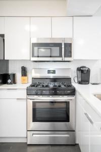 una cucina con piano cottura in acciaio inossidabile e forno a microonde di Vibrant Gem in the Heart of Midtown Walkscore 93 ad Atlanta