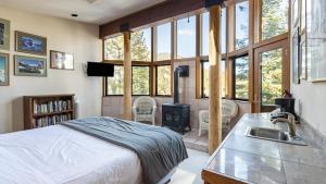 a bedroom with a bed and a kitchen with a stove at Mt. Jola by AvantStay A 5-minute walk away to Palisades and lifts. in Olympic Valley