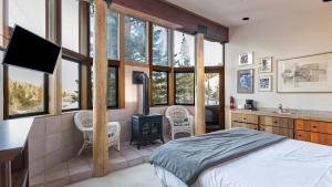 a bedroom with a bed and a tv and some windows at Mt. Jola by AvantStay A 5-minute walk away to Palisades and lifts. in Olympic Valley