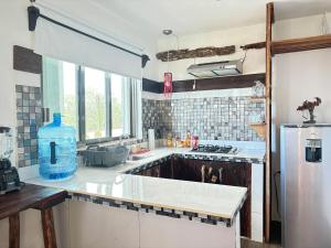 a kitchen with a sink and a refrigerator at CasaMarena in Isla Mujeres