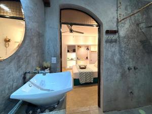 a bathroom with a sink and a bedroom with a bed at CasaMarena in Isla Mujeres +9 photos