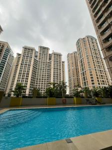 マニラにあるHawaii Theme Ortigas MRT Ayala 30th Megamall Podium Free Netflix Fast Internet Poolの高層ビルの前にあるスイミングプール