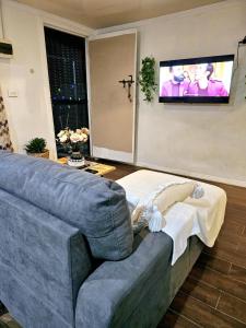 a living room with a couch and a tv at Sigatoka Town HomeStay In Coral Coast in Singatoka