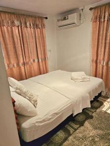 a bed in a room with orange curtains at Sigatoka Town HomeStay In Coral Coast in Singatoka