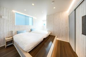 ein Schlafzimmer mit einem großen Bett in einem Zimmer in der Unterkunft Villa Uminosora - Vacation STAY 99828v in Karatsu