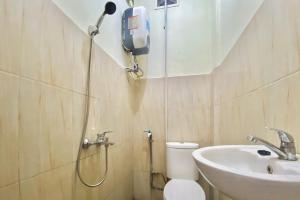a bathroom with a shower and a toilet and a sink at RedDoorz at Sonya Homestay Tebing Tinggi in Tebingtinggi