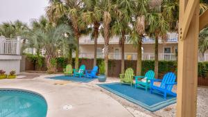 a patio with blue and green chairs next to a swimming pool at A Piece of Heaven by AvantStay Private Pool Sleeps 14 Pet-friendly in Santa Rosa Beach