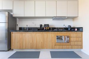 a kitchen with white cabinets and a counter top at Apt Novo 20º Andar, Perto de Tudo! in Goiânia