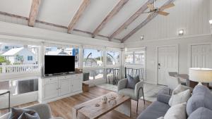 a living room with a couch and a tv at Beach Retreat w Sundeck Golf Cart Bikes Bungalow House by AvantStay in Seacrest