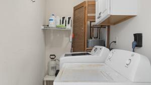 a kitchen with a white counter top and a sink at Beach Retreat w Sundeck Golf Cart Bikes Bungalow House by AvantStay in Seacrest +28 photos
