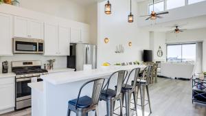 a kitchen with white cabinets and a bar with stools at Beachfront 2BR w Deck Views Direct Sand Access Strand Way A in Oceano