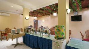 a restaurant with a counter with sinks and chairs at Hotel Permata Bandara in Jakarta