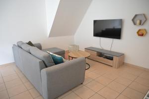 a living room with a couch and a tv at Appartement Le Cap Trégor Centre Ville in Perros-Guirec
