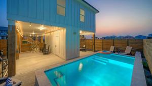 a swimming pool in front of a house at Sleeps 24 2 Homes Priv Pool Swing Bar Patio Lounge Near Nature Preserve in Port Aransas