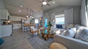 a living room with a couch and a table at Sleeps 24 2 Homes Priv Pool Swing Bar Patio Lounge Near Nature Preserve in Port Aransas