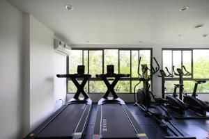 a gym with several treadmills and a row of windows at Fantasea Condo Kamala A503 2BDRM by Phuket Sabay Rent in Kamala Beach +25 photos