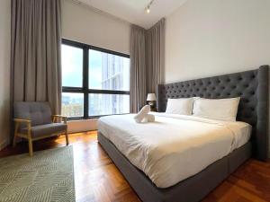 a bedroom with a large bed with a chair and a window at The Mews Kuala Lumpur in Kuala Lumpur +64 photos