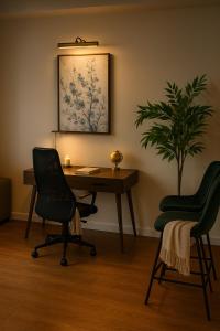 an office with a desk and two chairs and a plant at High stay, new furniture apartment in Glendale