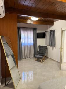 a living room with a mirror and a chair at Casa Loma 2 RHODES-FAMILY VILLA,PRIVATE POOL & FARM in Rhodes Town