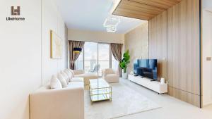 a living room with a white couch and a tv at Dubai Skyline Balcony Views near Burj Khalifa & Dubai Mall Luxury 2BR - Like Home in Dubai