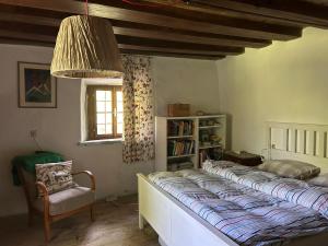 a bedroom with a bed and a chair and a window at 1690 Heritage Farmhouse-barn in Kuchl