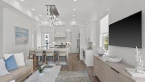 a living room and kitchen with a couch and a table at Pool Hot Tub Firepit Golf Cart Included Walk to Beach Near Gulf Place in Santa Rosa Beach