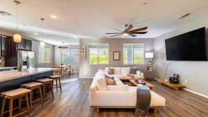 a living room with a white couch and a kitchen at Luxe Indio Stay w Pool Tiki Bar Fire Pit Near Coachella Longfellow in Indio