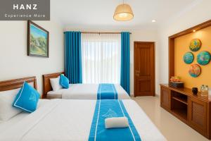 a hotel room with two beds and a window at S79 Mai Mountain House in Xuân Vũ