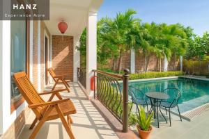 a balcony with chairs and a table next to a swimming pool at S79 Mai Mountain House in Xuân Vũ