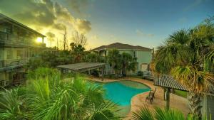 una piscina in un cortile con alberi e una casa di Pool Walkable to Old Town Eateries Nightlife Shops Palm Palace by AvantStay a Port Aransas