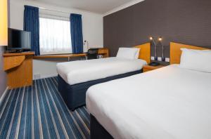 a hotel room with two beds and a television at Holiday Inn Express Southampton West by IHG in Southampton