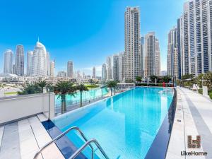 a swimming pool on the roof of a building with tall buildings at Dubai Skyline Balcony Views near Burj Khalifa & Dubai Mall Luxury 2BR - Like Home in Dubai