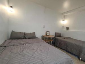 a bedroom with two beds and a table in it at วังเหนือริเวอร์ไซด์ Resort&Hotel in Ban Wang Nua