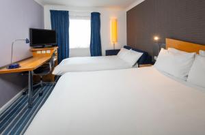 a hotel room with two beds and a desk at Holiday Inn Express Southampton West by IHG in Southampton +43 photos