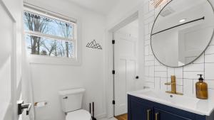 a bathroom with a sink and a mirror and a toilet at Sage Lodge by AvantStay 15 Min to Downtown Deck in Asheville +52 photos