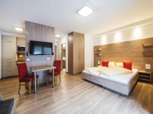 Un dormitorio con una cama, un escritorio y un televisor. en Apartment in Kleinarl near Ski-Area with Balcony & Parking, en Kleinarl