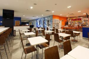 ein Restaurant mit Tischen und Stühlen und einer Bar in der Unterkunft One Ciudad de México Periférico in Mexiko-Stadt